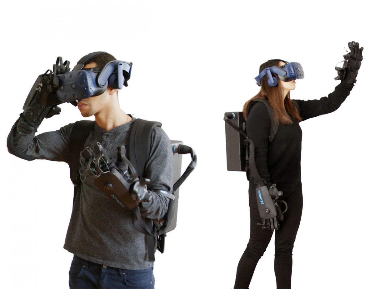 Man and woman using the HaptX Gloves DK2 in backpack mode, allowing them to walk around room